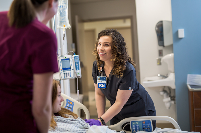 A Carilion nurse checking in with a patient at the bedside